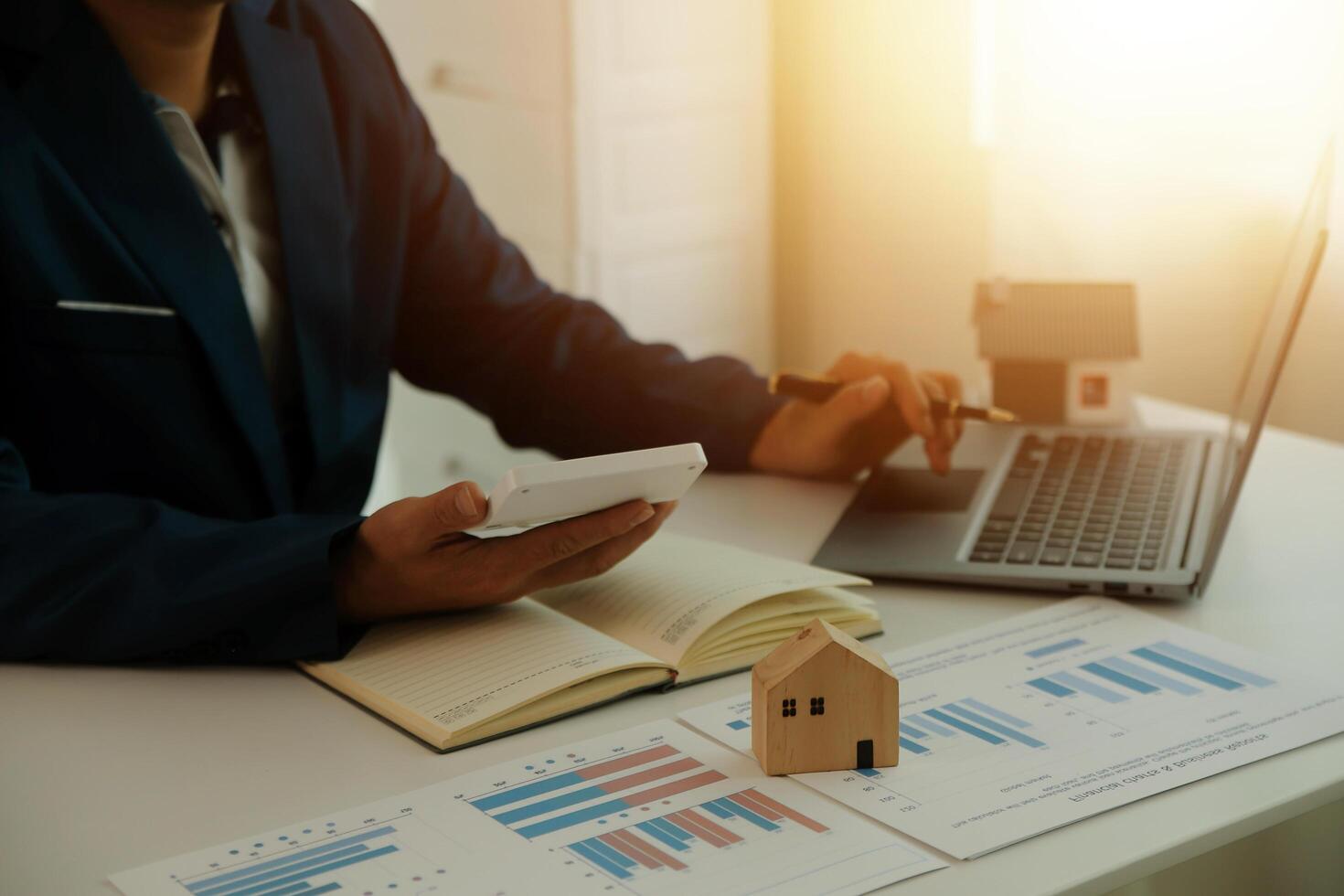 Businessmen holding pens, signing home titles with insurance, care about real estate services and the idea of real estate agents offering interest in installments to their customers. photo