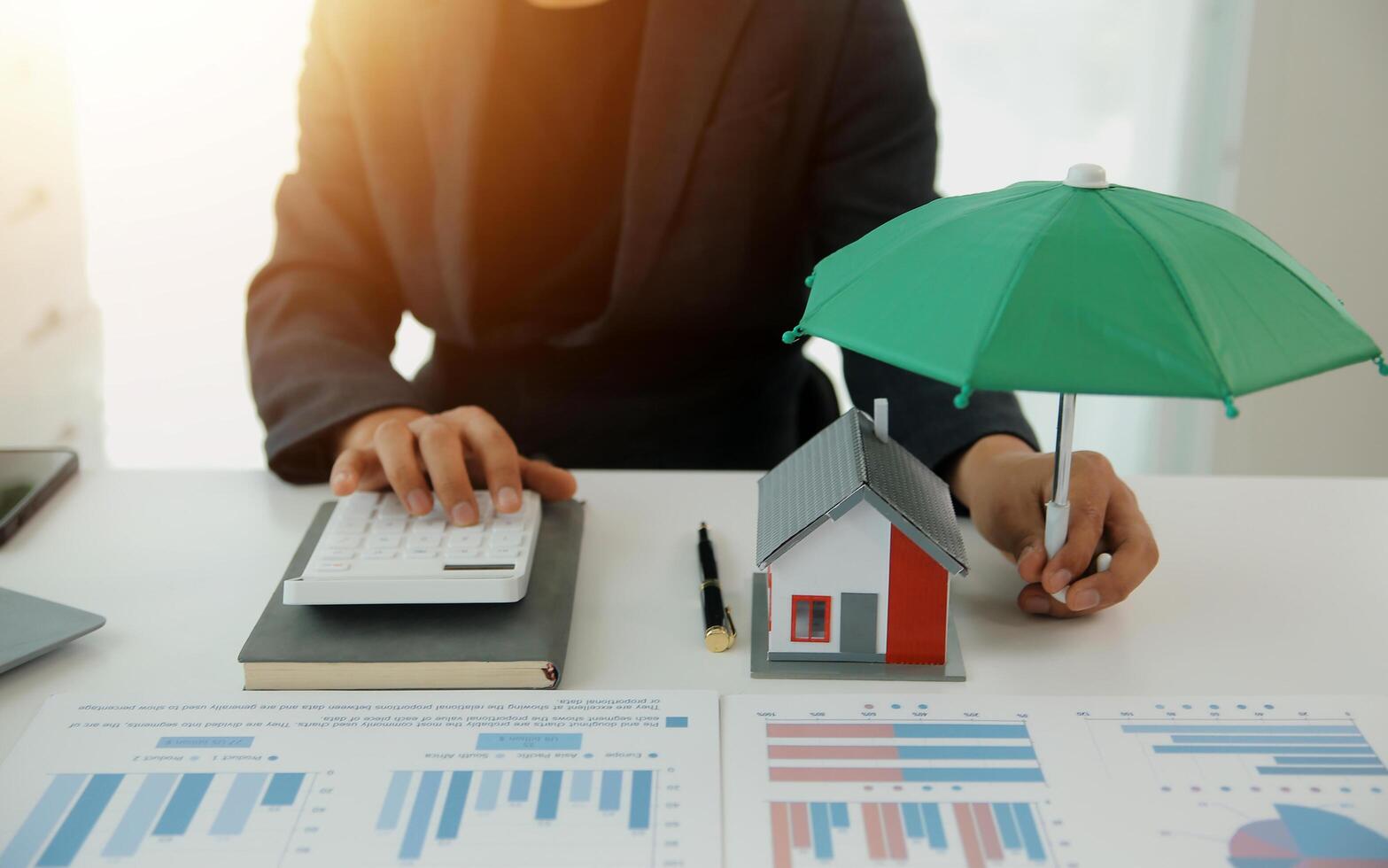 Businessmen holding pens, signing home titles with insurance, care about real estate services and the idea of real estate agents offering interest in installments to their customers. photo