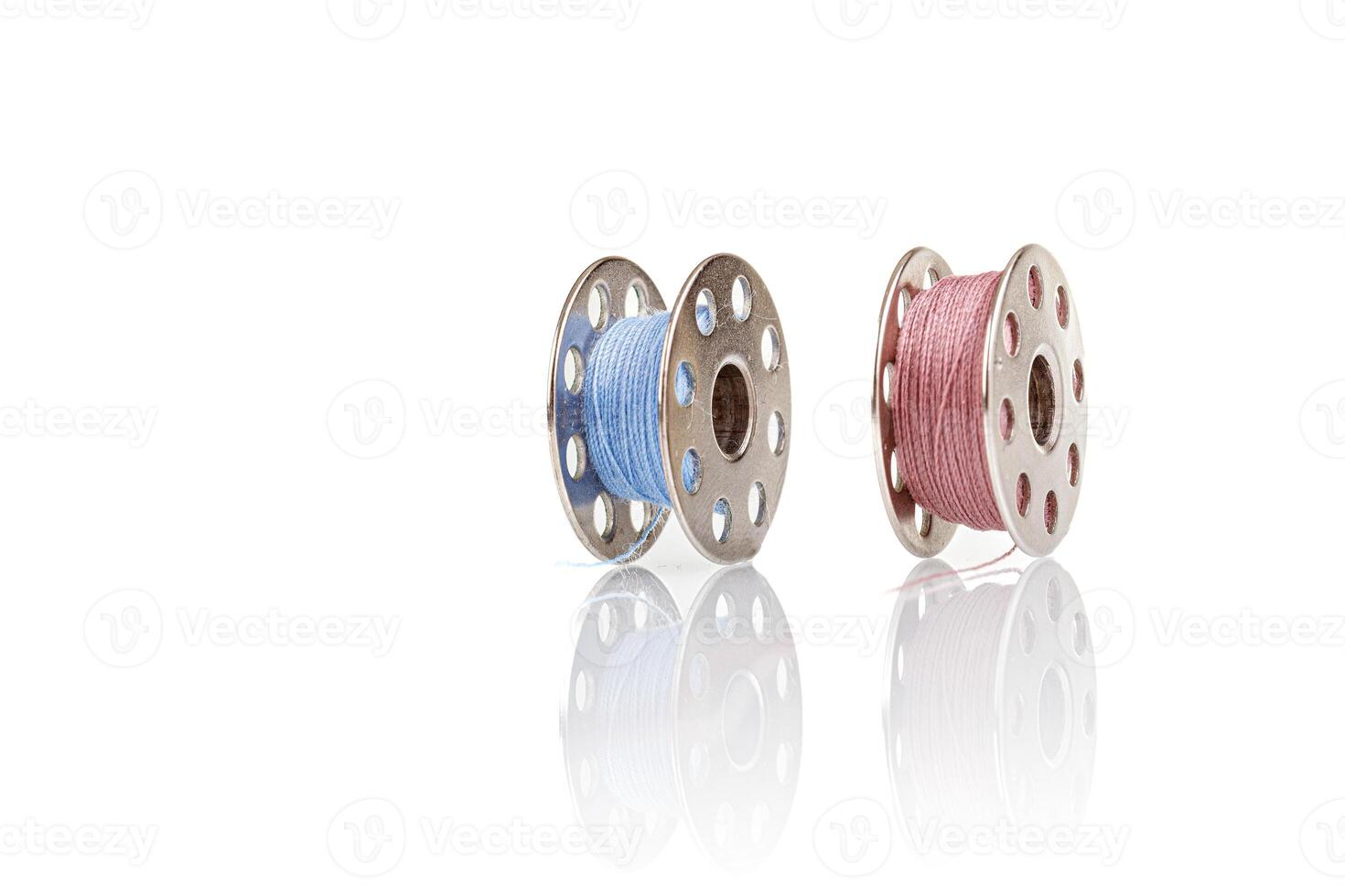 spools of blue and pink thread on a white background photo
