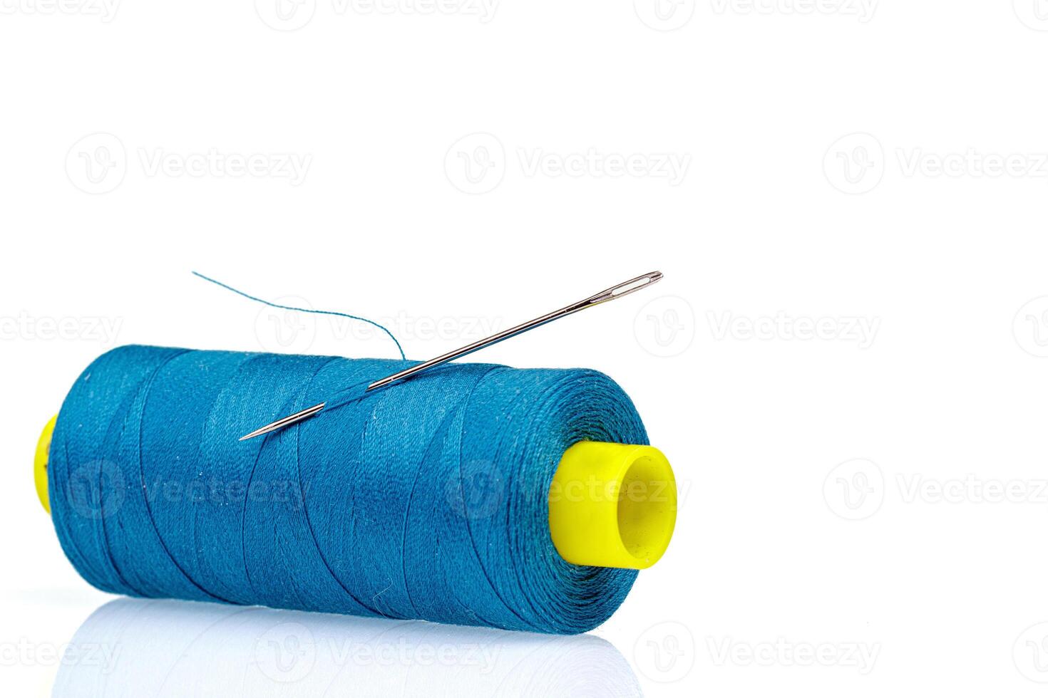 Macro skein of blue thread with a needle on a white background photo
