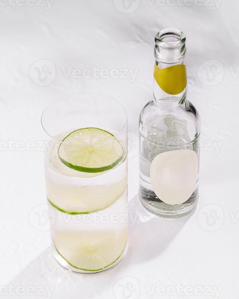 Sparkling water with lime slices refreshing beverage on white background photo