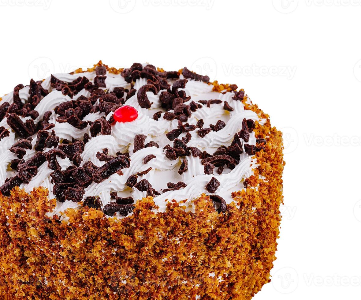 Delicious round cake with chocolate sprinkles and white cream standing on white background photo