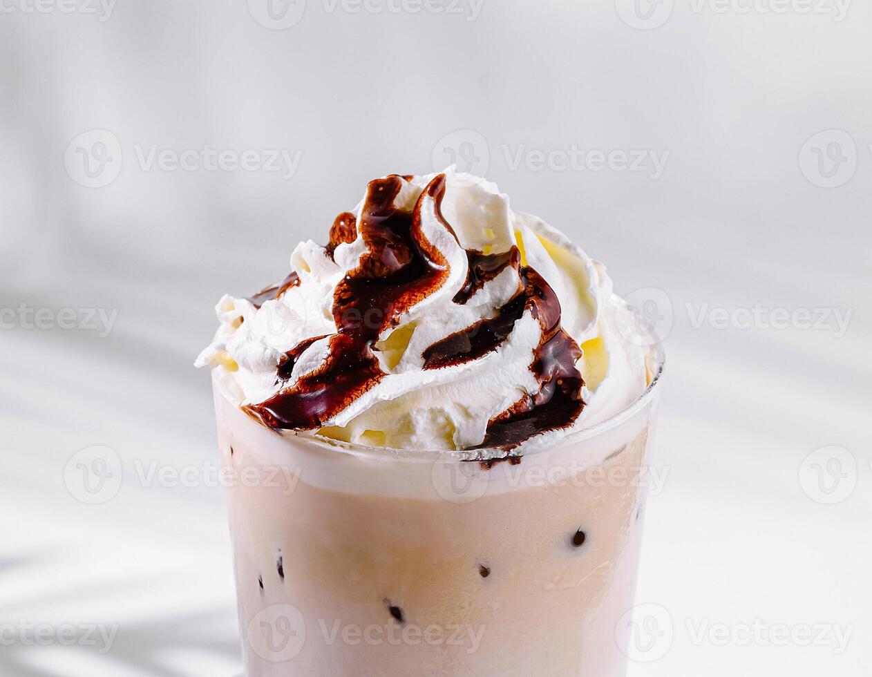 Iced coffee with whipped cream and chocolate sauce on white background photo