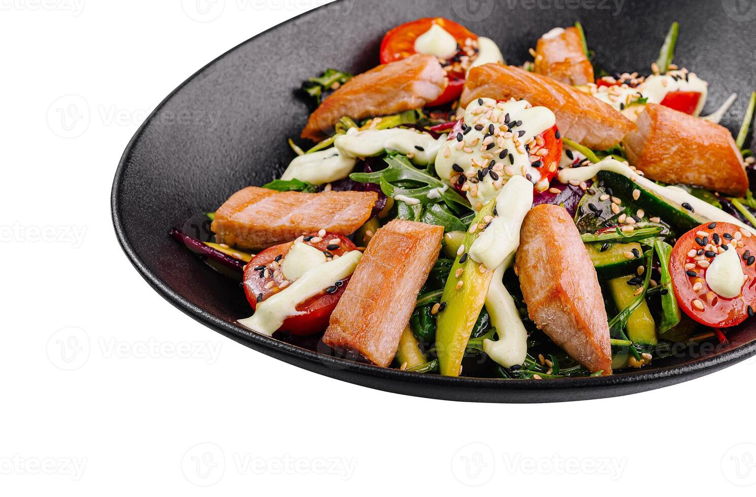 Salmon salad with tomatoes and arugula dressed with creamy sauce in black bowl photo