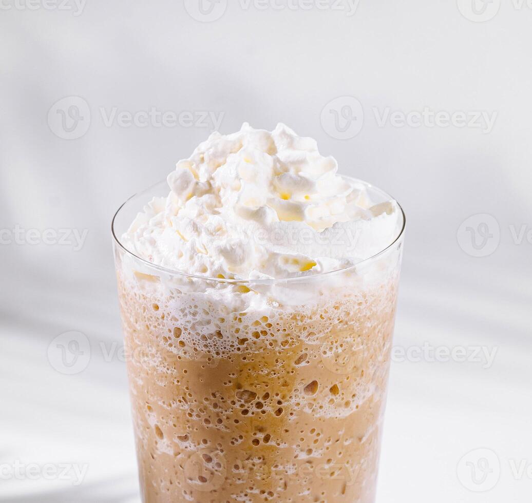 Iced coffee topped with whipped cream in a tall glass photo