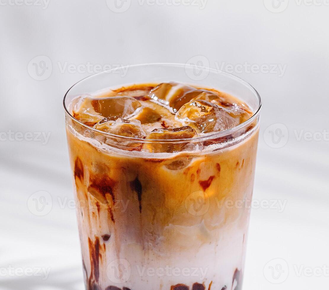 Iced coffee latte with milk and chocolate syrup drizzled on glass photo