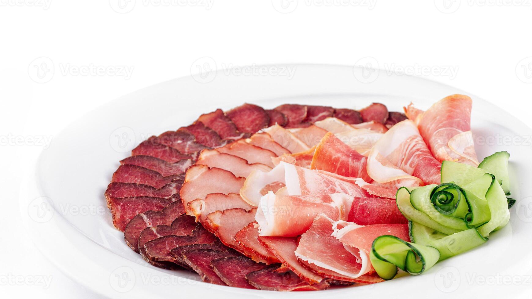 Plate presenting delicious cured meat slices with cucumber decoration photo