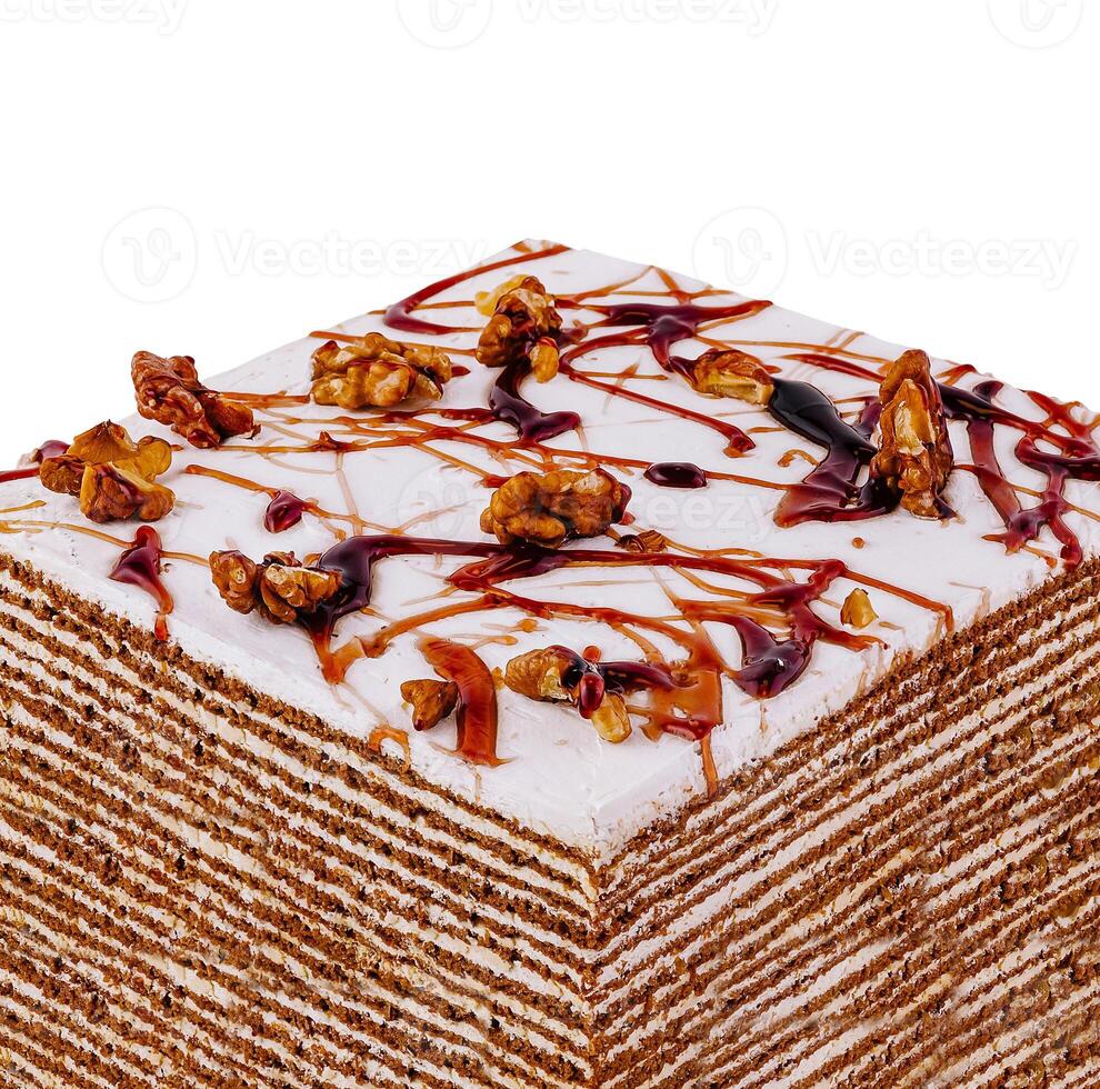 Delicious square honey cake decorated with walnuts and caramel drizzle photo