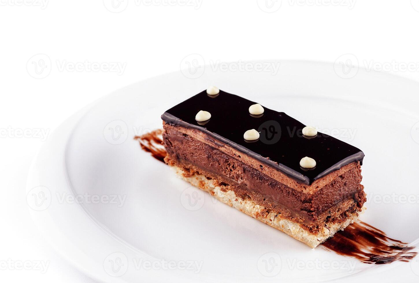 Delicious chocolate cake lying on white plate decorated with chocolate sauce photo