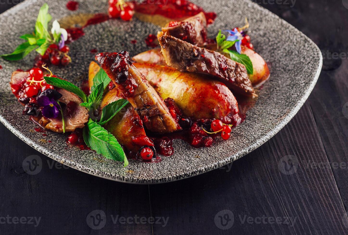 Roasted duck breast with pear and red currant sauce on plate photo