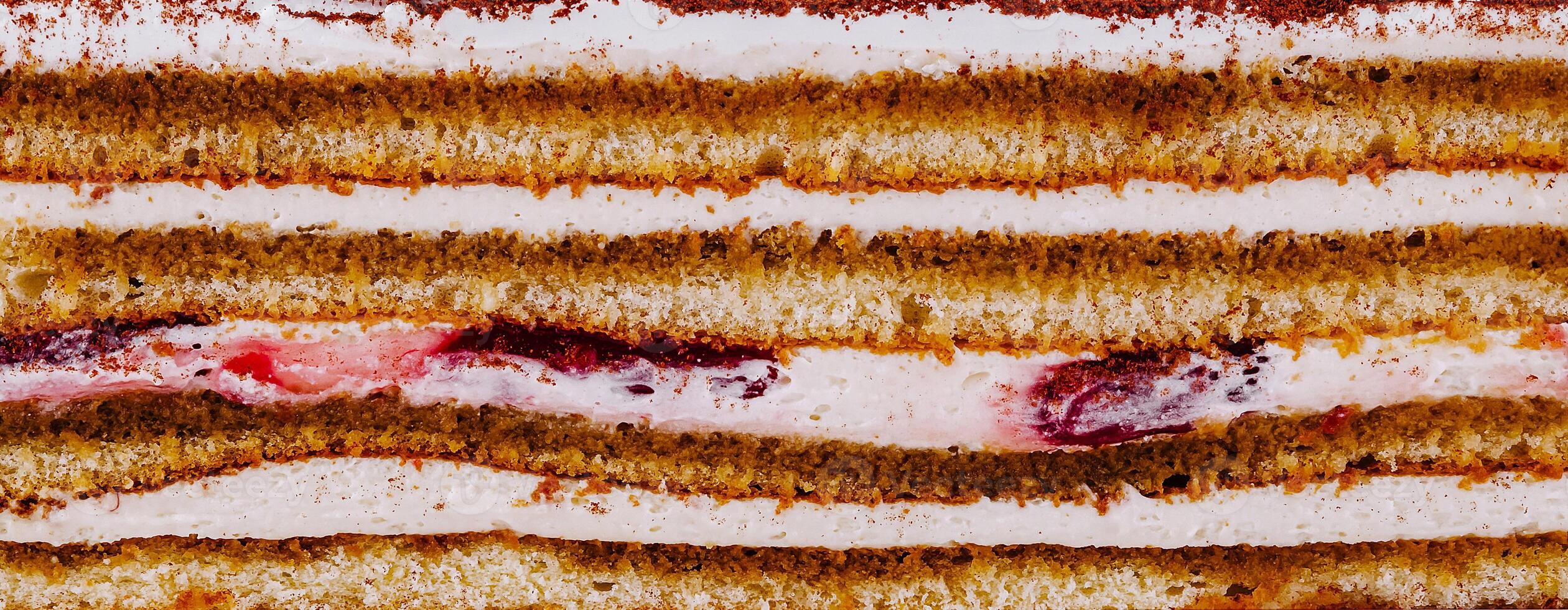 Delicious cake with layers of biscuit, cream and fruit jelly is waiting to be eaten photo