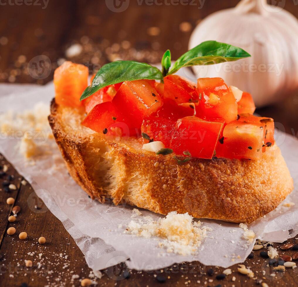 Delicious bruschetta with tomatoes, basil and garlic on wooden table photo
