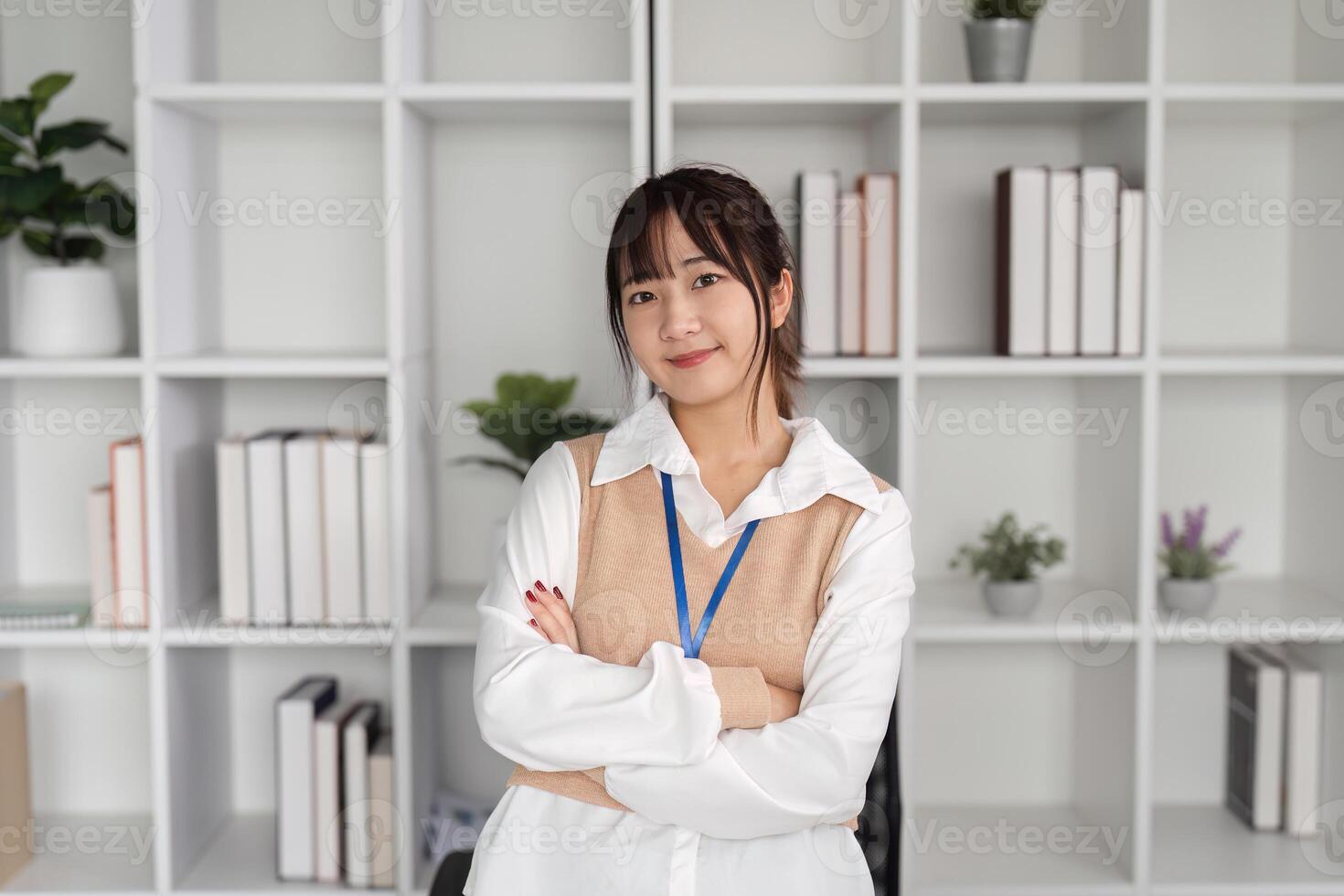 Confident Young Female Office Worker Posing in Modern Workspace with Shelves and Plants in Background photo