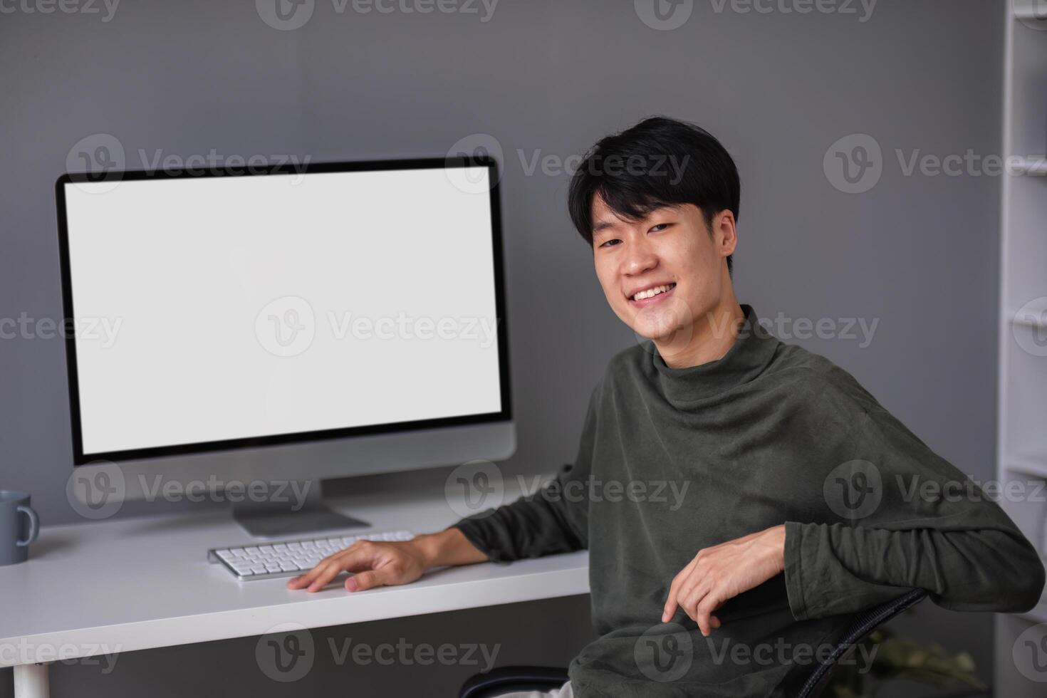 Young Boy Studying Online at Home with Computer, Engaged in E-Learning and Remote Education, Smiling and Sitting at Desk photo
