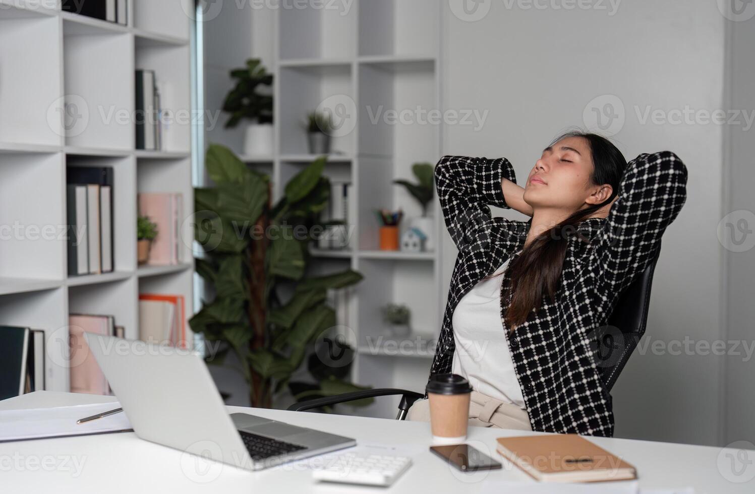 Exhausted Business Woman Taking a Break from Work in Modern Office Environment, Battling Stress and Fatigue photo