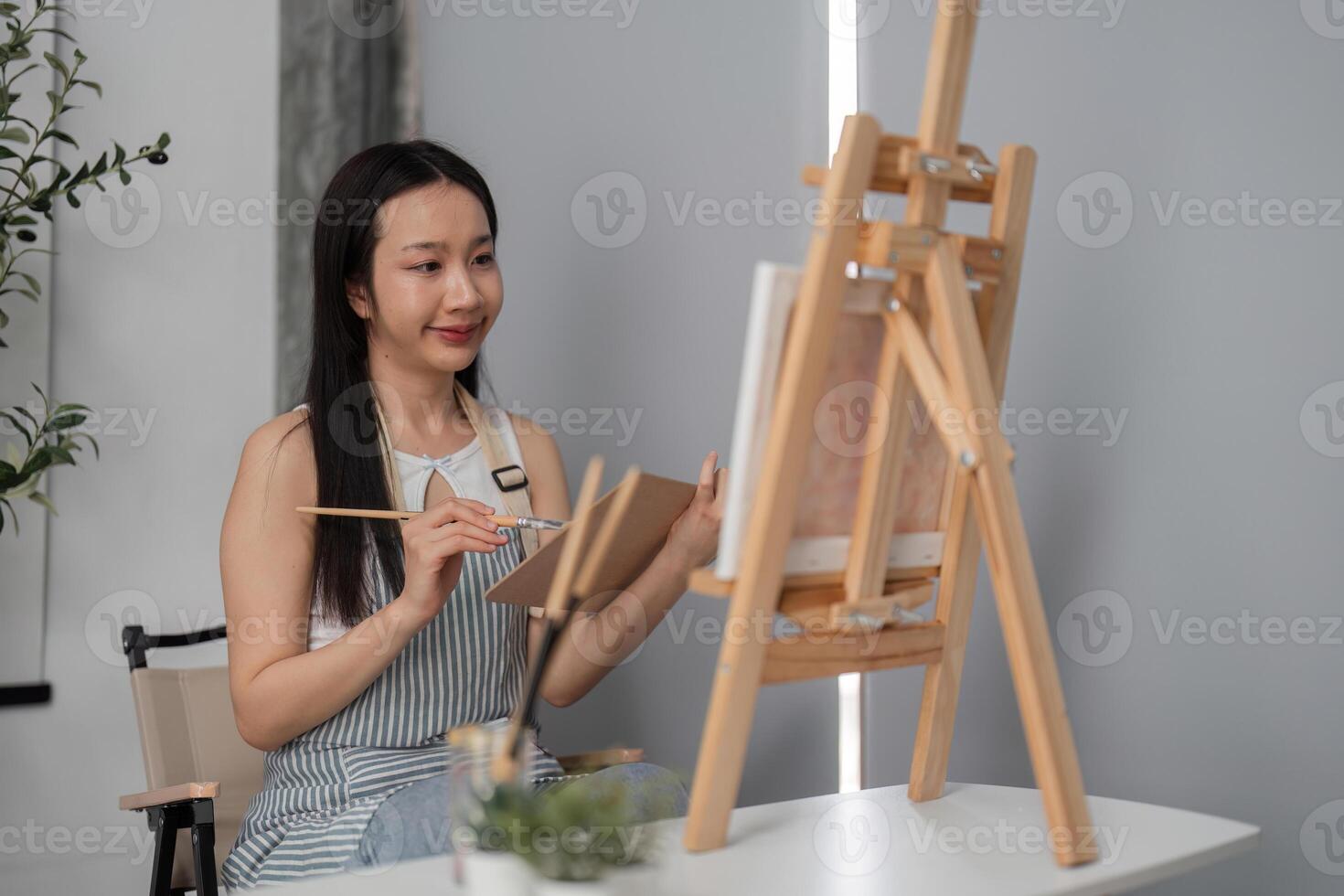 Young Woman Relaxing and Drawing a Picture in a Modern Room with Natural Light and Minimalist Decor photo