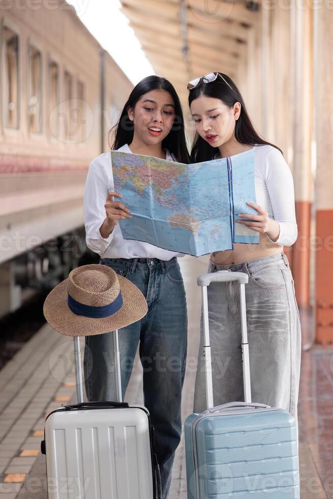 Two Young Friends Holding Maps and Waiting for the Train at a Station, Ready for a Travel Adventure photo