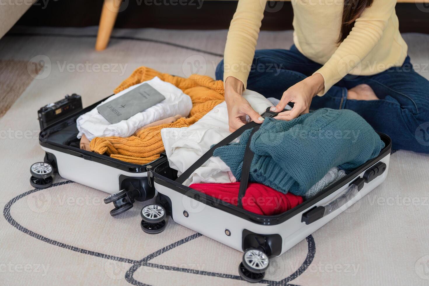 Young Woman Packing a Suitcase for Travel at Home, Preparing for Vacation or Business Trip, Organizing Clothes and Essentials photo
