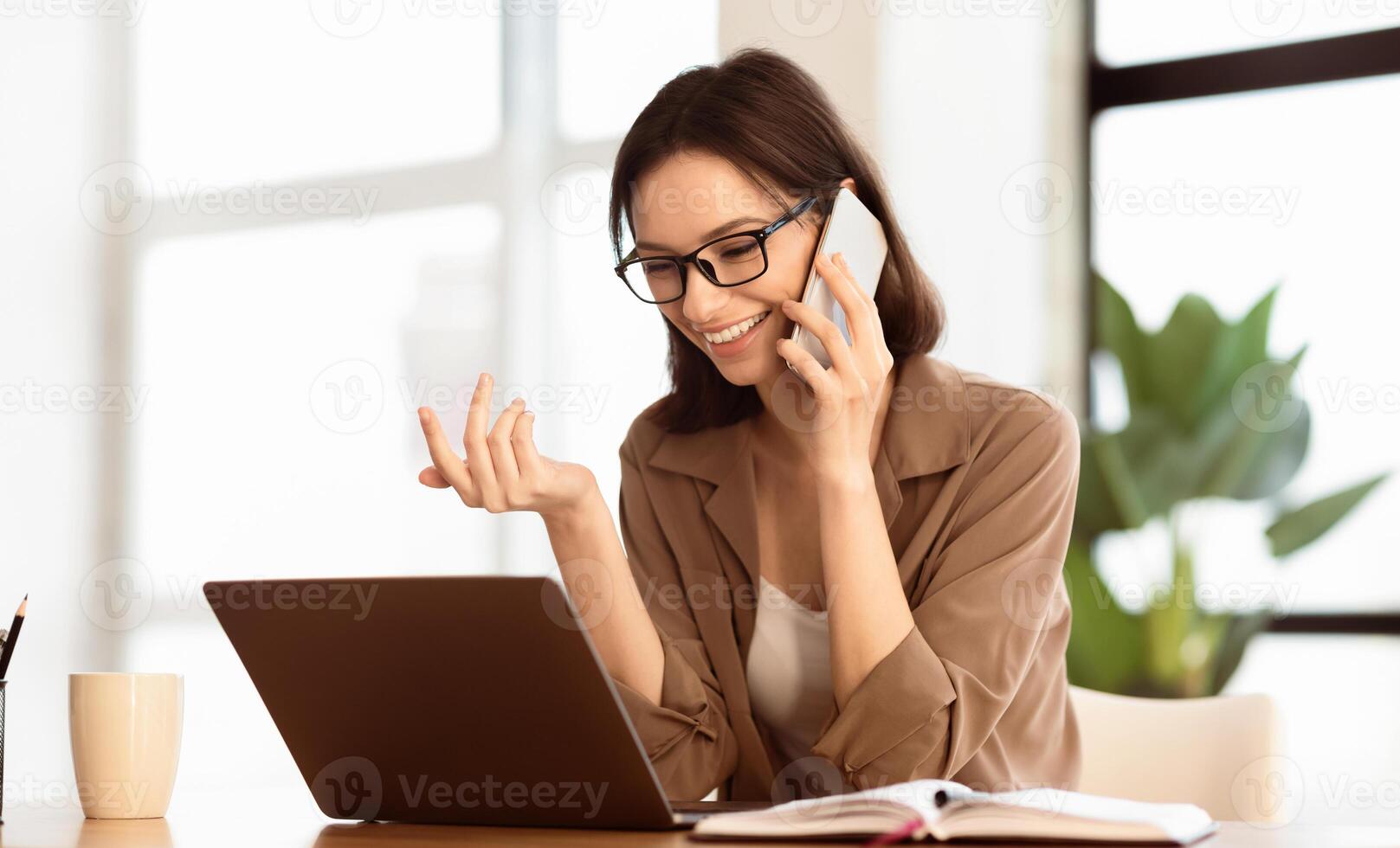 Business Conversation. Smiling manager wearing specs making phone call, talking with partners, using laptop, copyspace photo