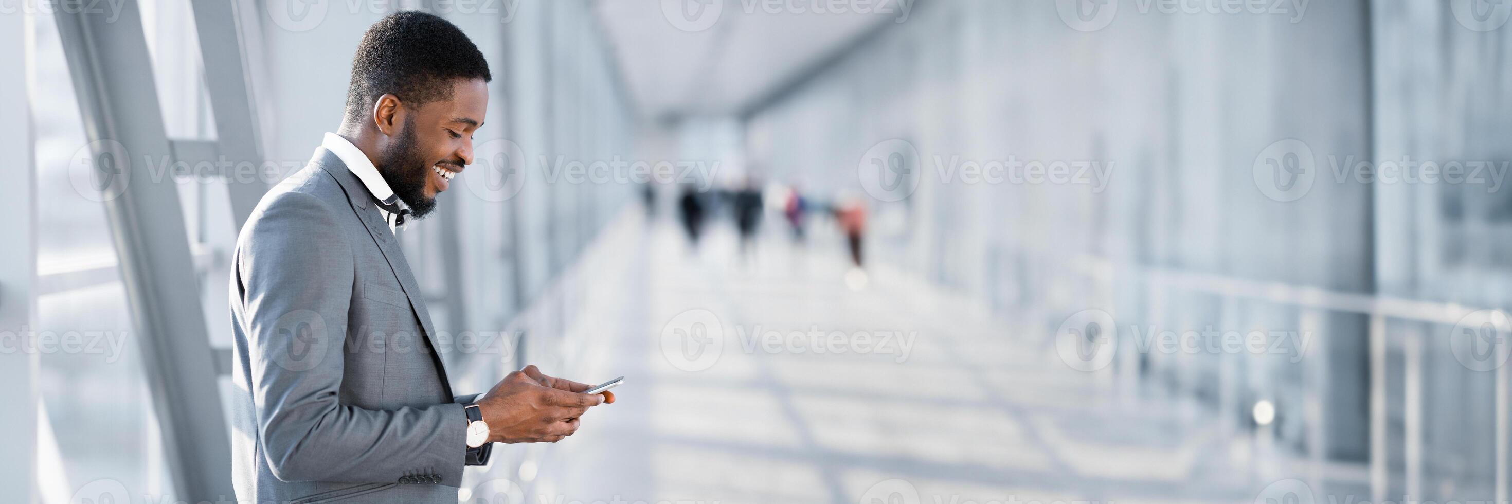 Always in Touch. African American Businessman Texting on Phone, Waiting for Flight at Airport, Side View, Panorama, Copy Space photo