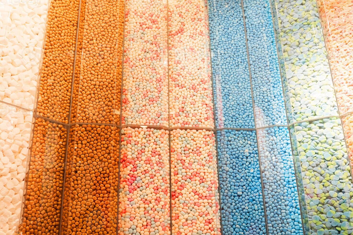 Rows of colorful jelly beans in glass containers. Candy store interior display photo