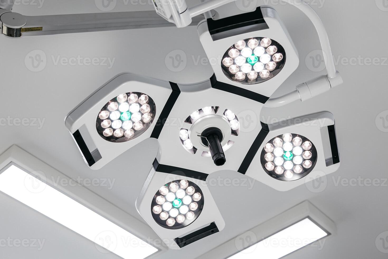 Bright surgical lights illuminate a modern hospital operating room, showcasing advanced medical technology. Ideal for promoting state-of-the-art healthcare services in your advertising photo