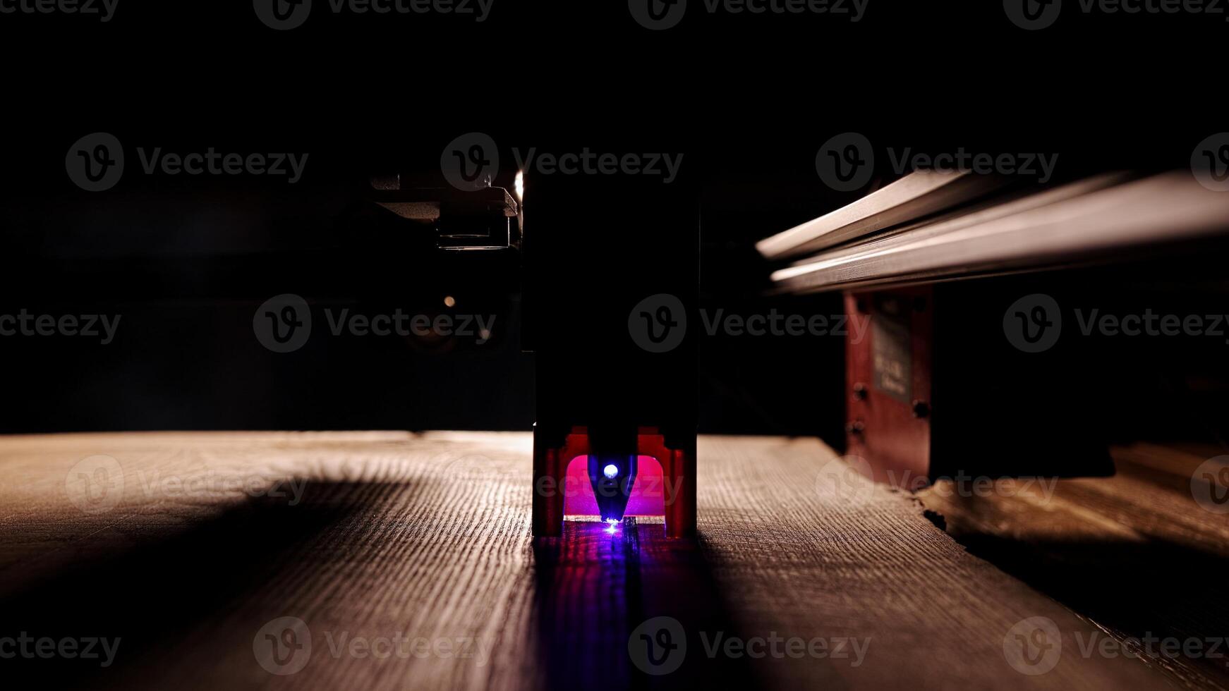 The process of laser wood cutting. A laser machine precisely carves lines on the surface, creating detailed and accurate designs. Perfect for themes of high-tech and manufacturing photo