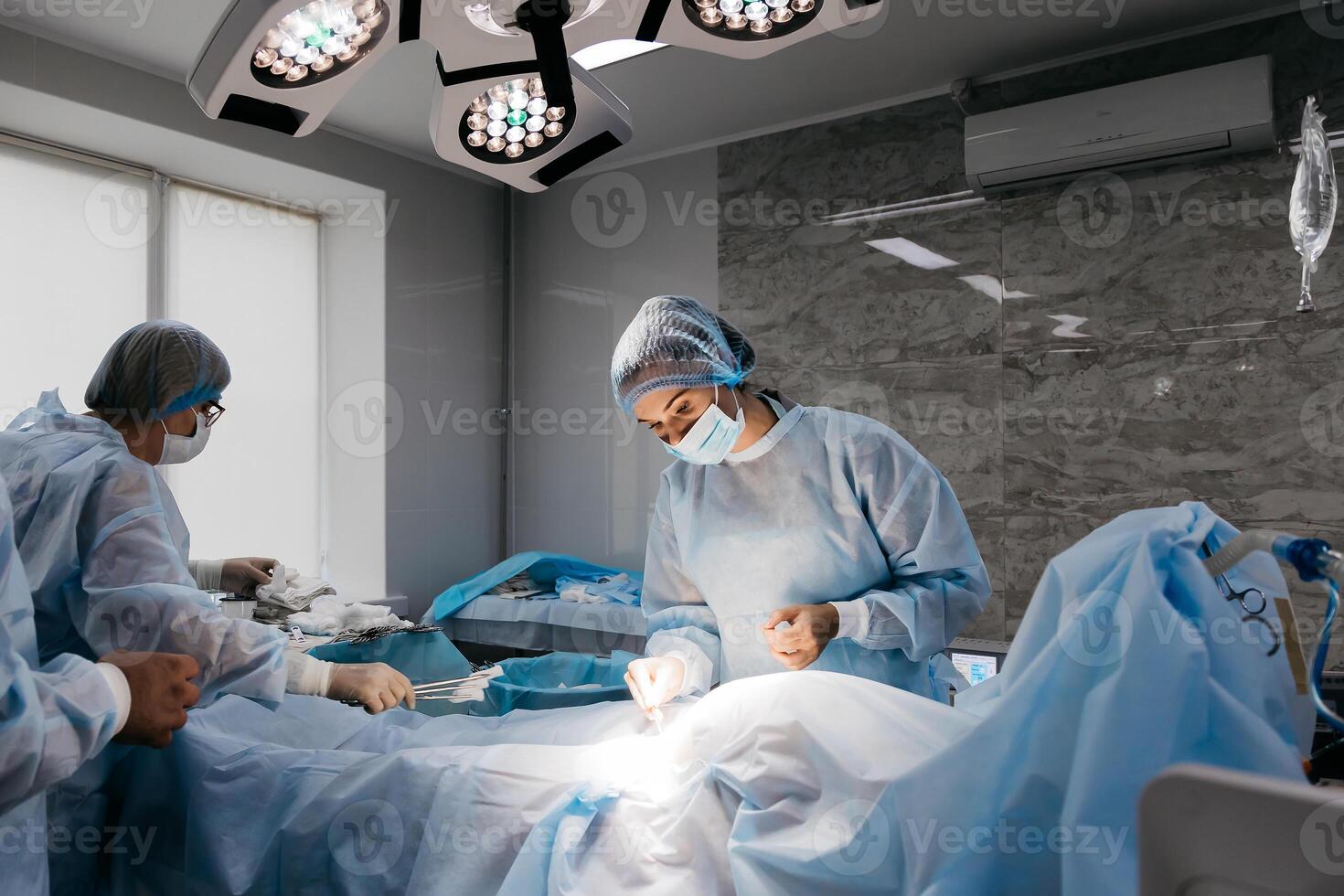 Surgeons performing a delicate operation in a modern operating room, surrounded by advanced medical equipment. The photo captures a moment of precision and expertise in a high-tech environment