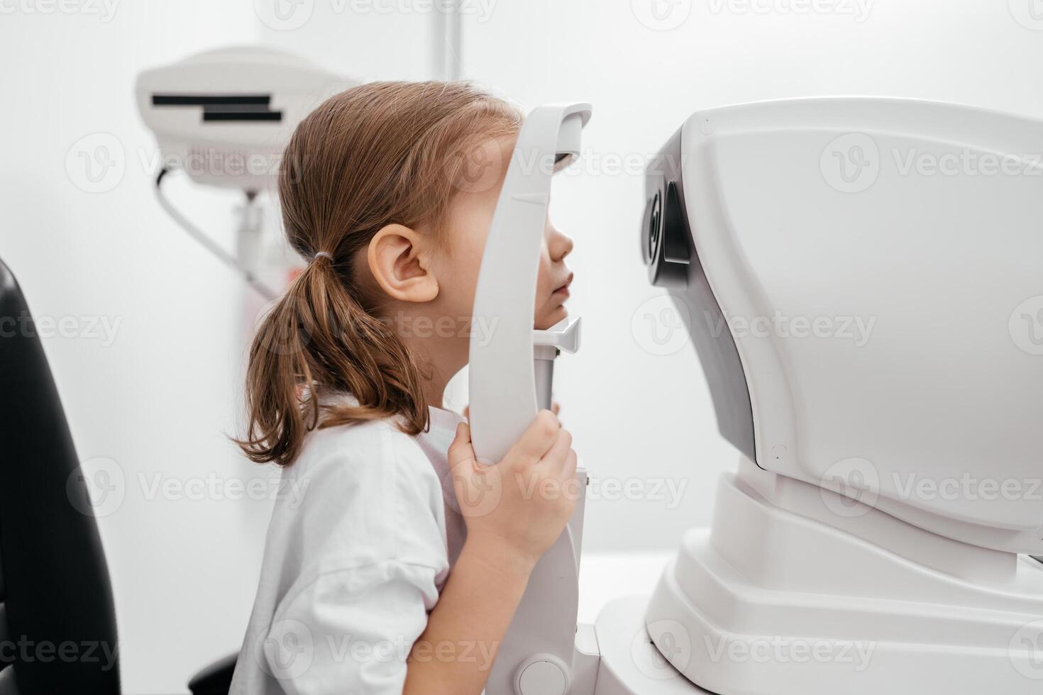 A child being examined with a slit lamp. A device with a microscope and focused light to assess lens and cornea conditions. Perfect for vision diagnostics photo