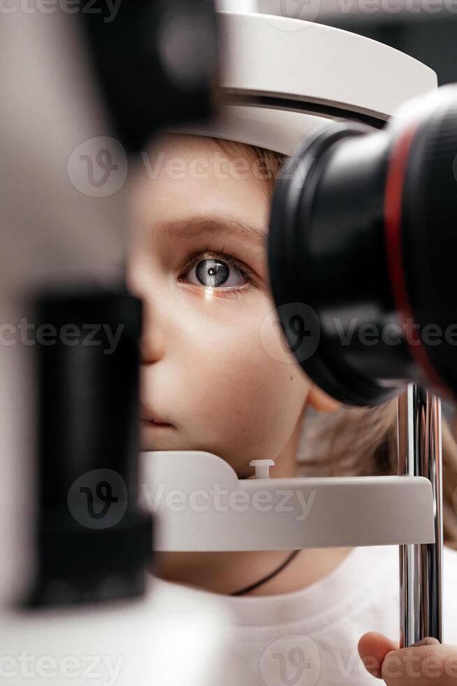 Child little girl getting an eye exam at ophthalmology clinic. Checking retina of a female eye close-up. Laser vision correction. Eyesight concept. Future technology, medicine and vision concept photo