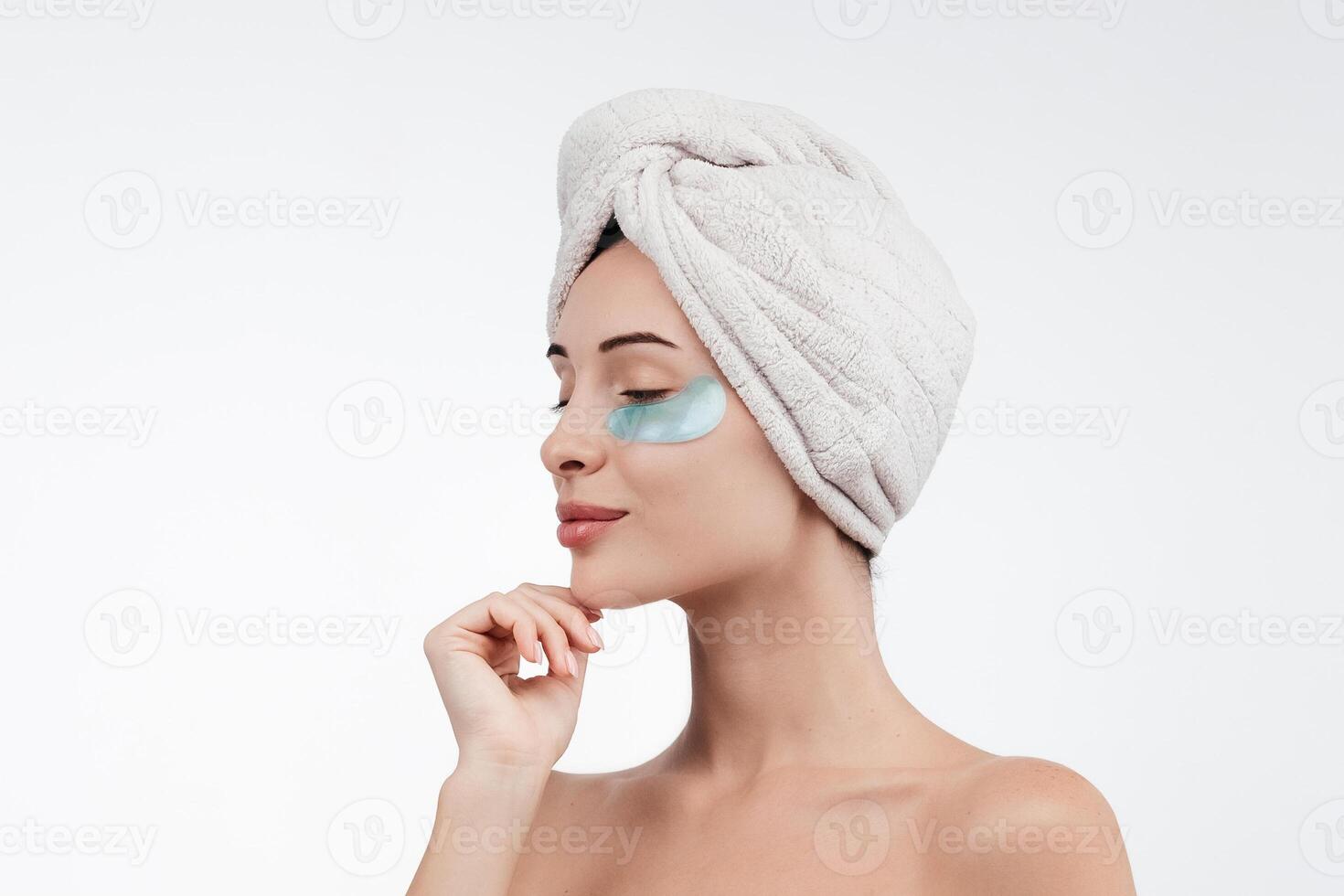 Close up of caucasian girl with natural no makeup, wears silicone under eye patches and smiling happy, using skincare products from dark circles, white background photo