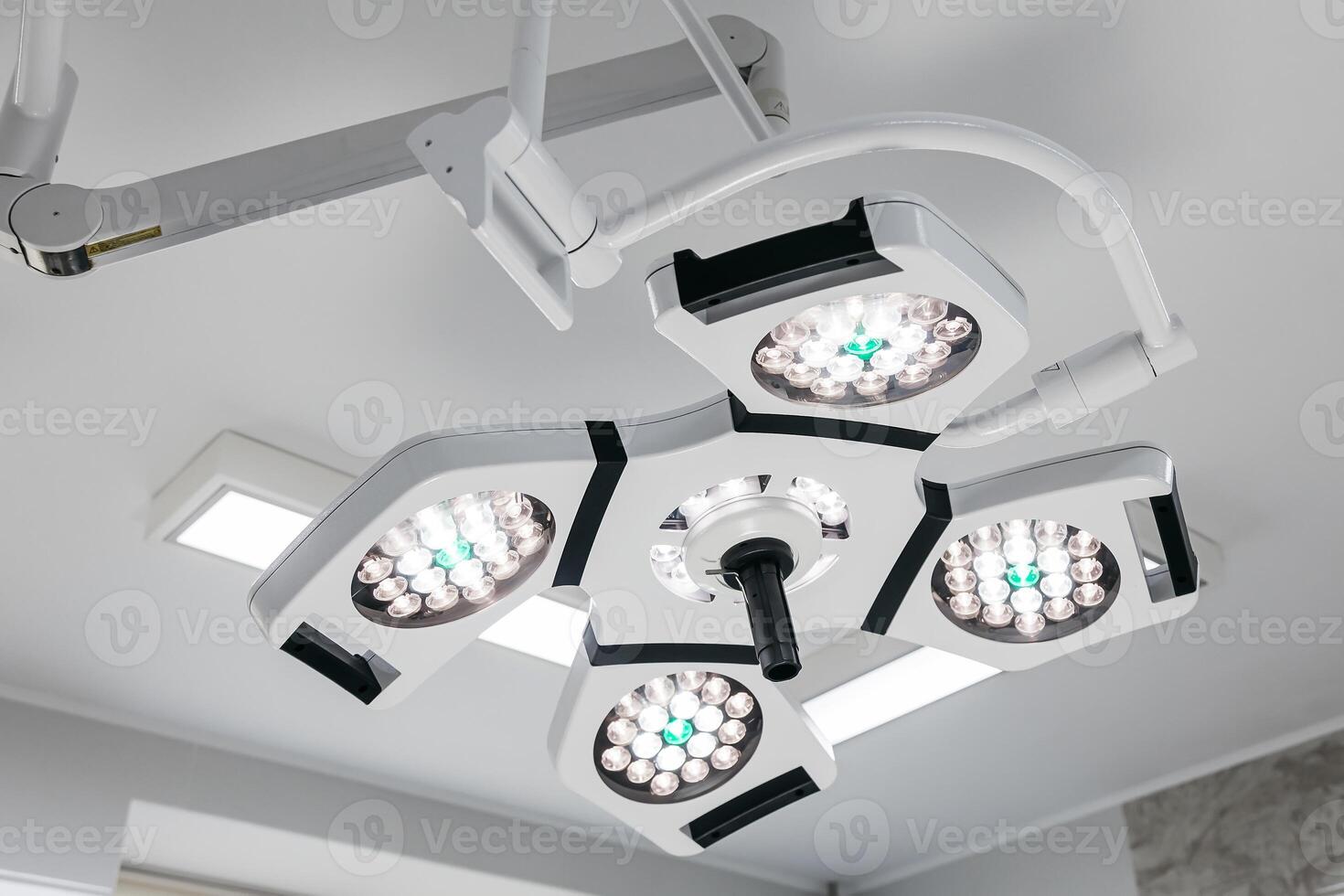 Bright surgical lights illuminate a modern hospital operating room, showcasing advanced medical technology. Ideal for promoting state-of-the-art healthcare services in your advertising photo