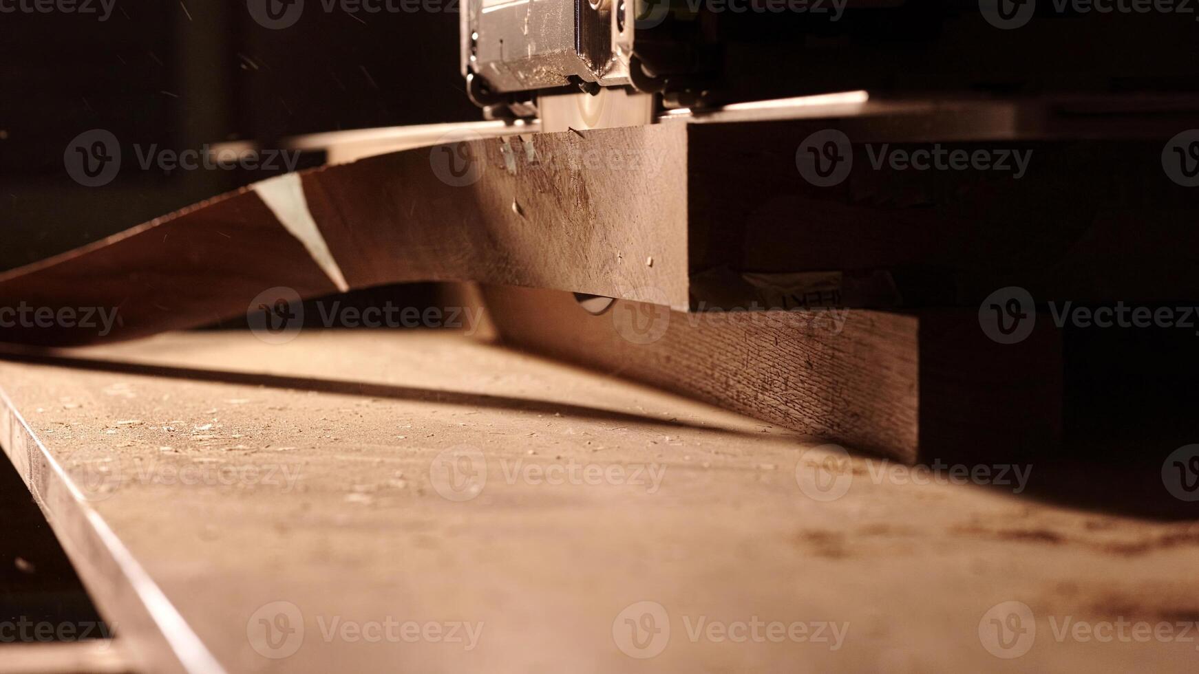 Carpenter using circular saw for cutting wooden plank. Man worker building wooden frame. Carpentry tools in use. Cutting a piece of wood in furniture factory. photo