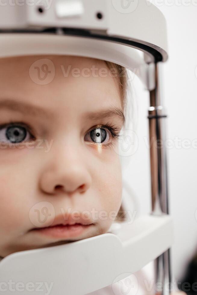 Child little girl getting an eye exam at ophthalmology clinic. Checking retina of a female eye close-up. Laser vision correction. Eyesight concept. Future technology, medicine and vision concept photo