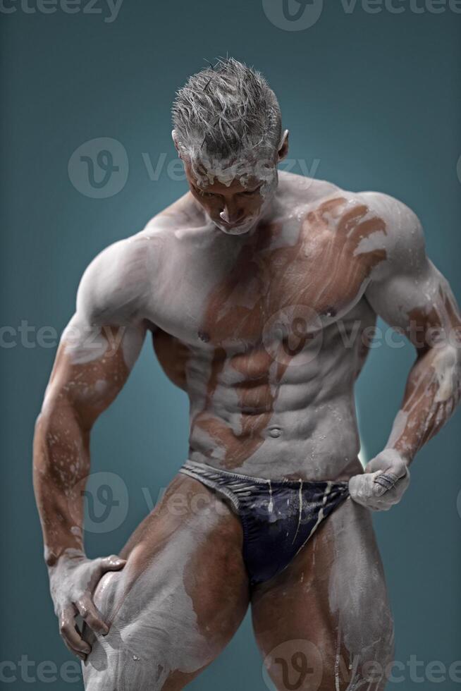 Muscular man touching himself, male posing in studio photo