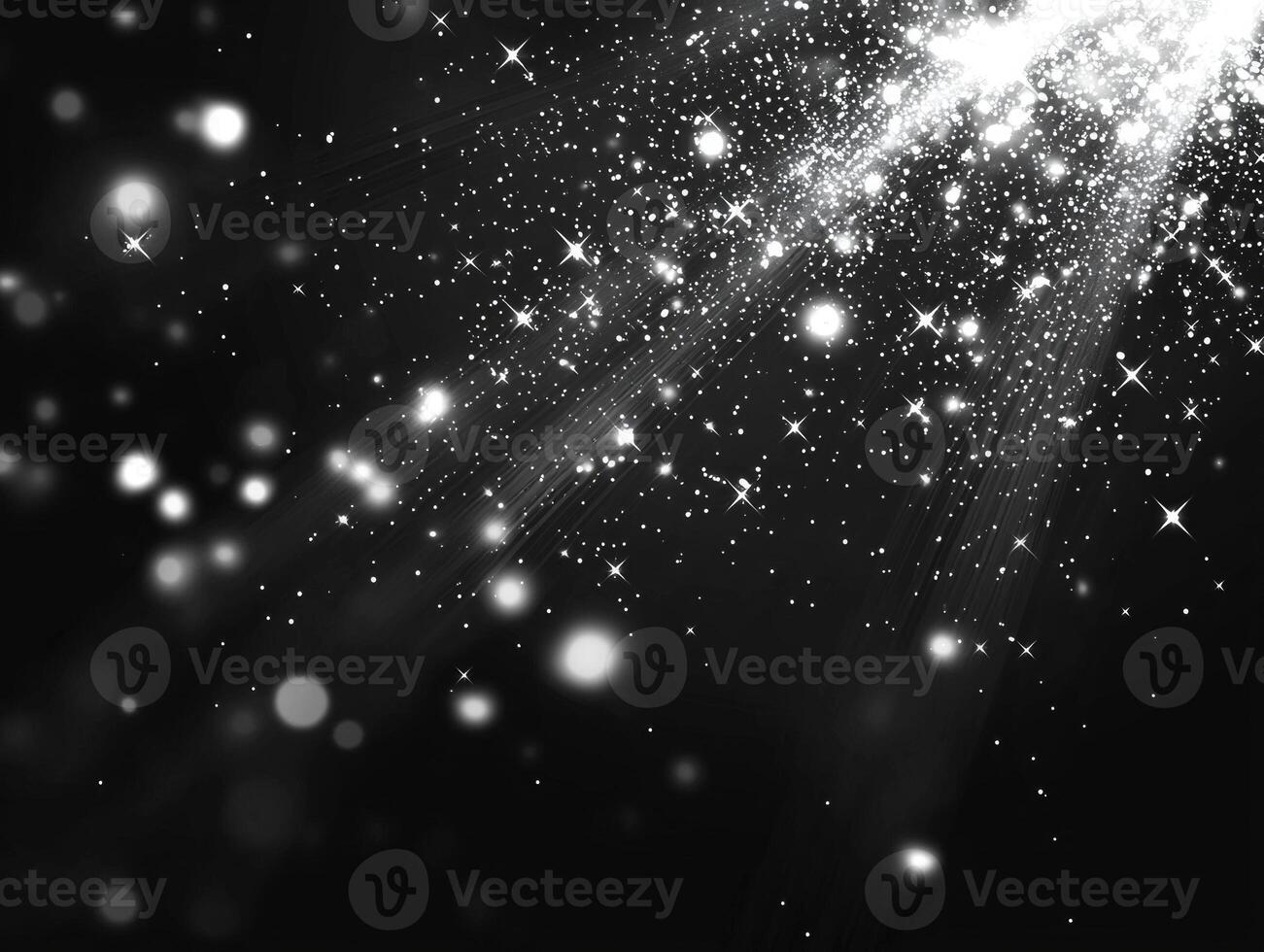 Small silver dots scatter chaotically across a dark background, some glowing brightly while others fade, creating a mesmerizing stardust effect reminiscent of the cosmos. photo