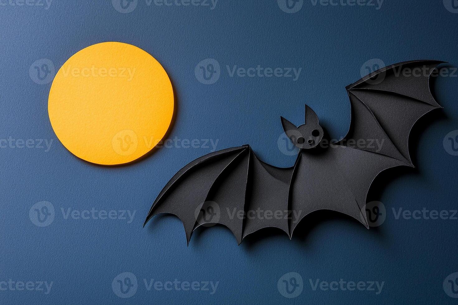 beautifully crafted paper bat soars across a deep blue sky, its wings intricately layered in black and grey, with a striking yellow moon illuminating the night. photo