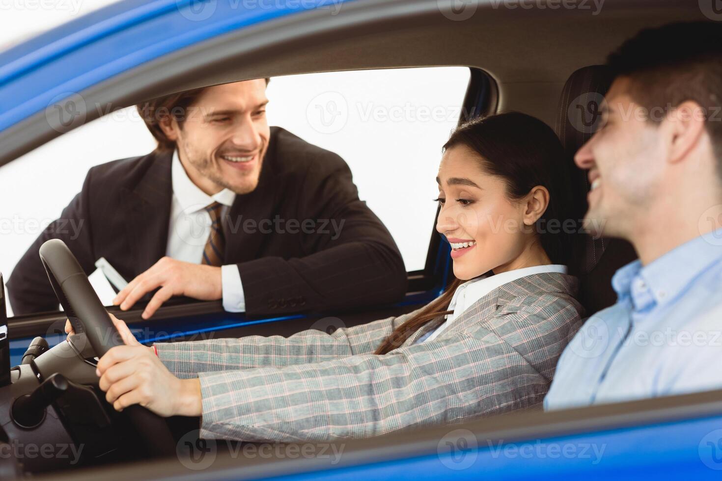 Automobile Test-Drive. Couple Buying Car Testing And Choosing Vehicle With Dealer Sitting In Auto Dealership Store photo