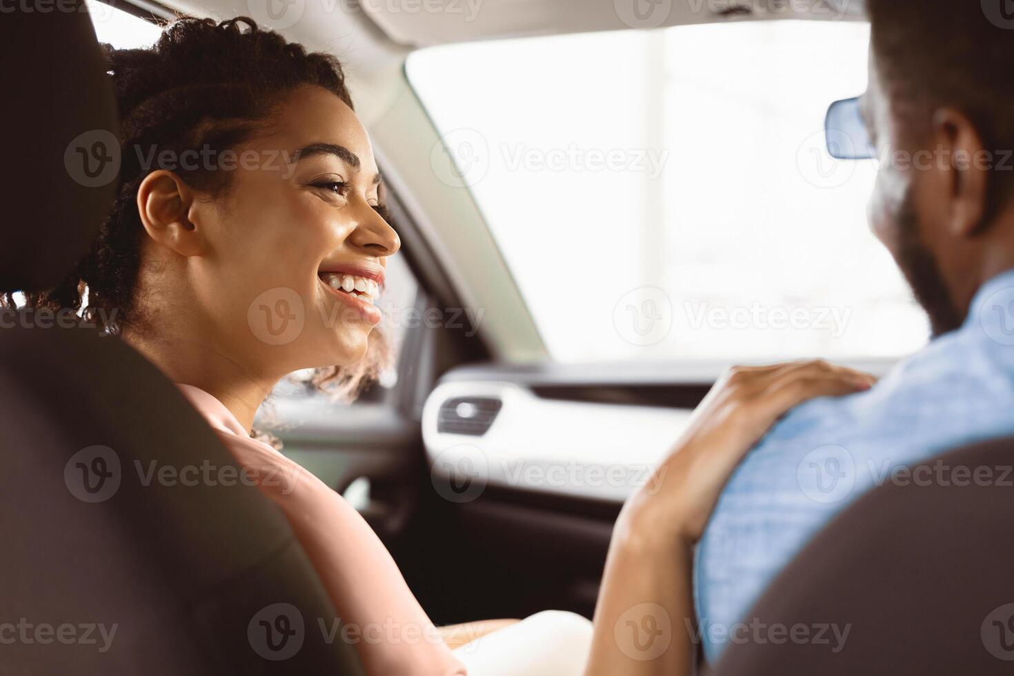 African American Couple In Car, Wife Touching Husband's Shoulder Happy About Buying New Auto Sitting In Dealership Store. Selective Focus photo