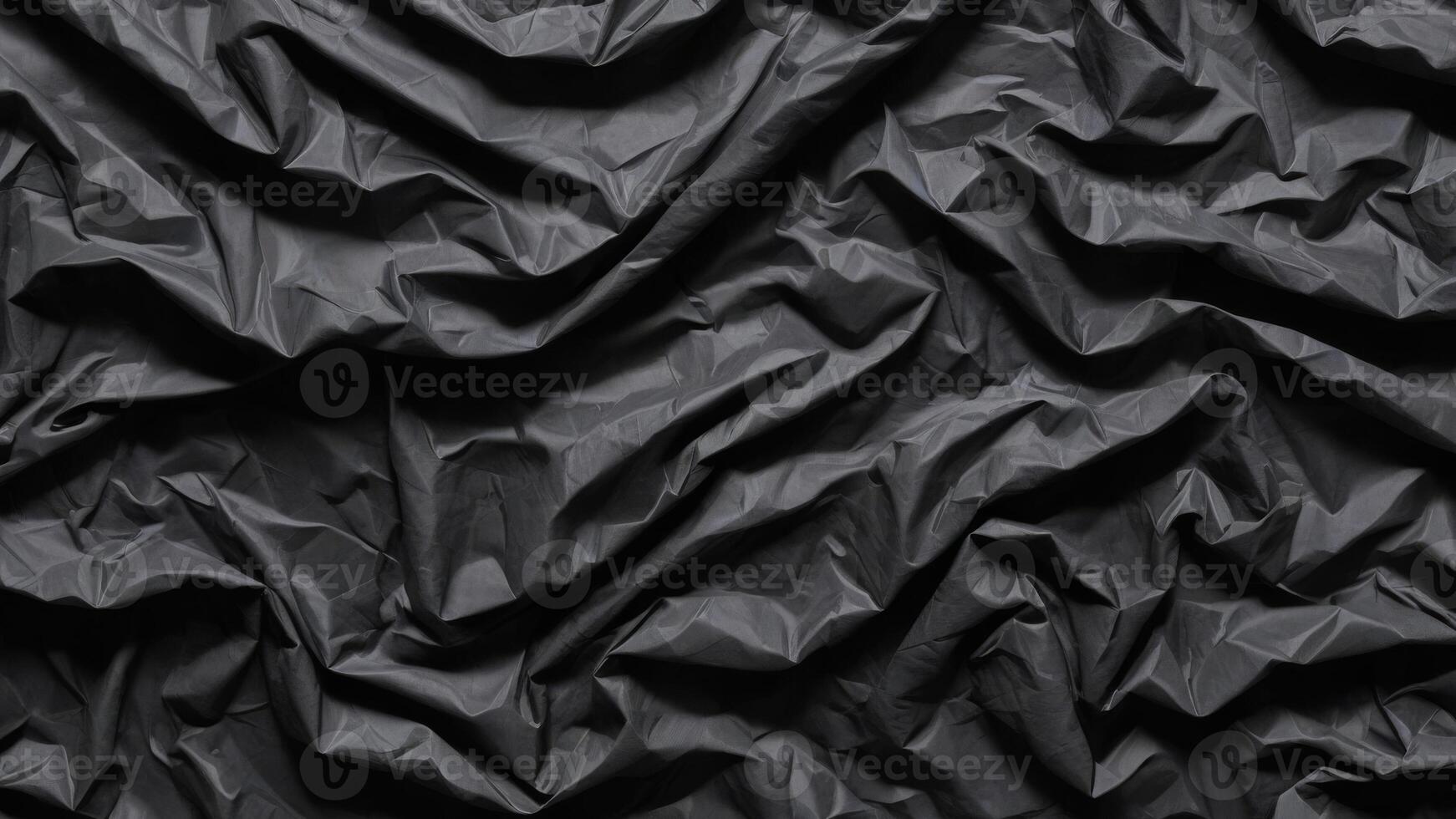 crumpled black plastic texture as background. photo