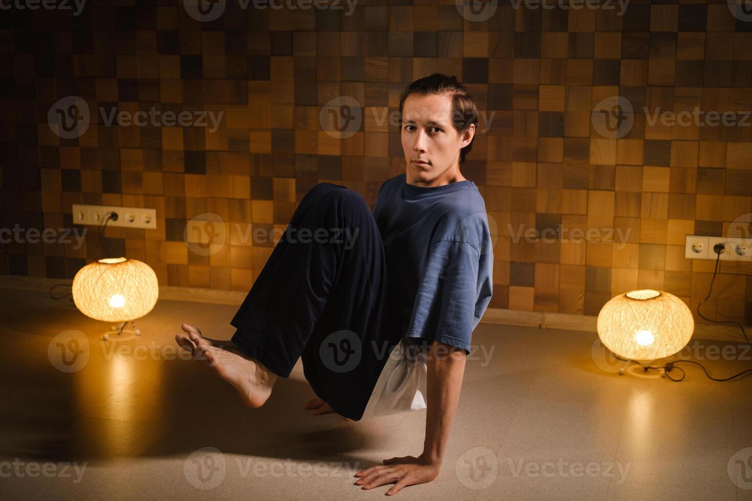 a man in a sports uniform does yoga in a fitness room. the concept of a healthy lifestyle photo