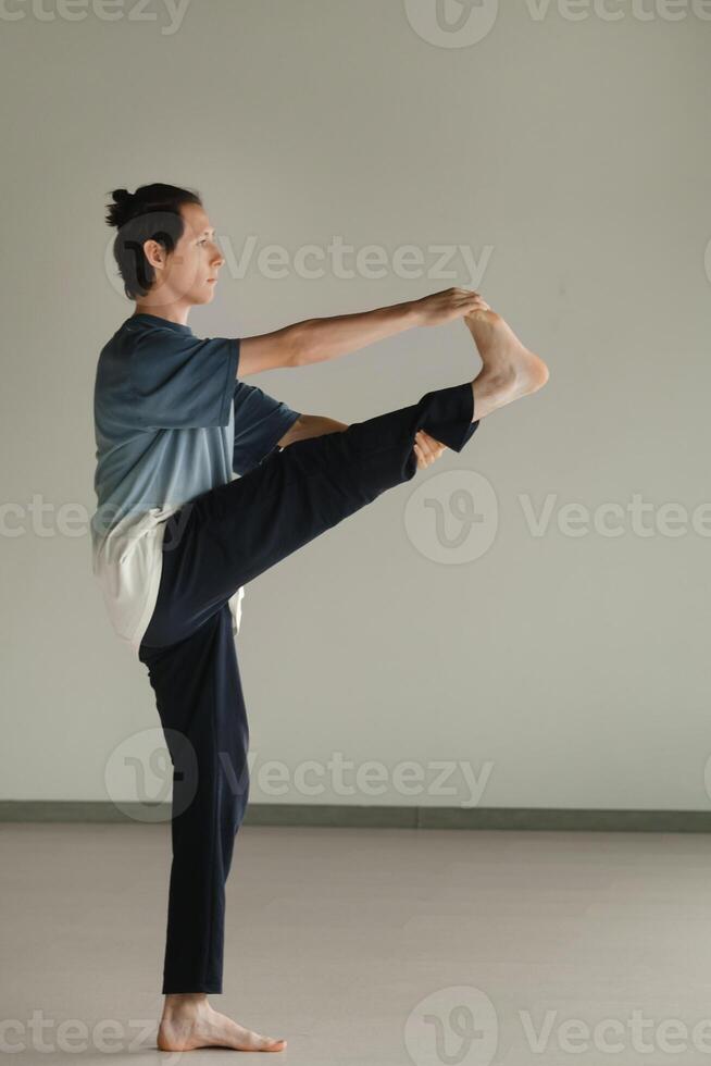a man in a sports uniform does yoga in a fitness room. the concept of a healthy lifestyle photo