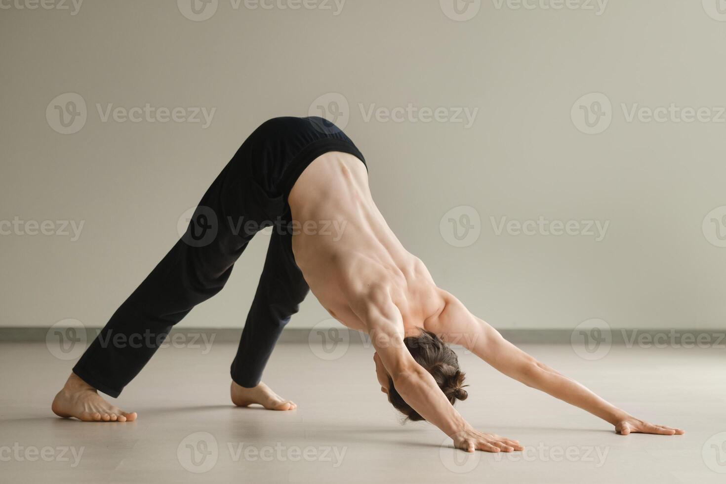 a man with a naked torso does yoga in the gym. the concept of a healthy lifestyle photo
