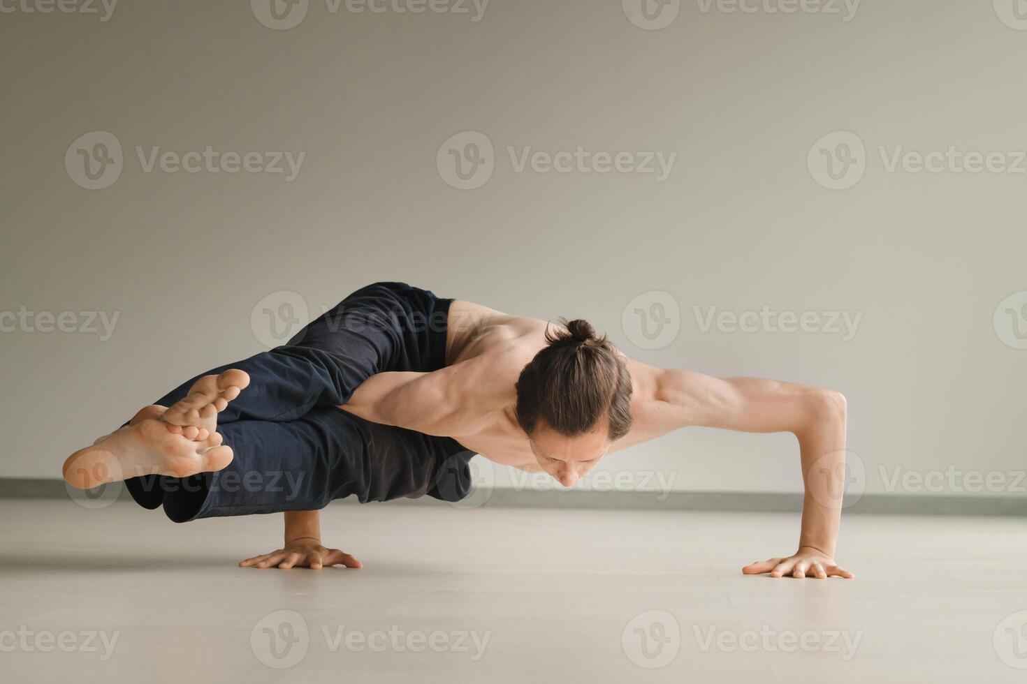 a man with a naked torso does yoga in the gym. the concept of a healthy lifestyle photo