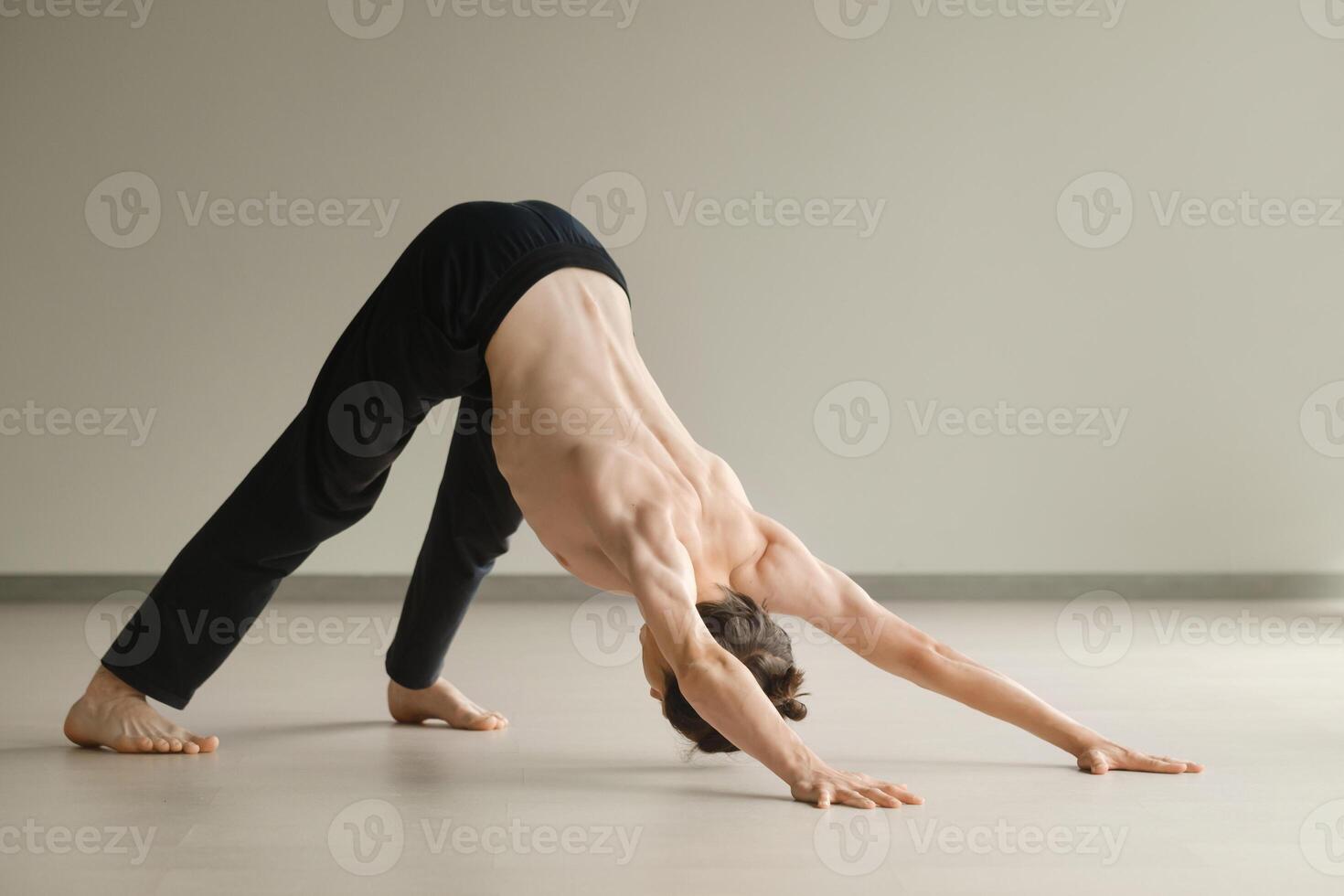 a man with a naked torso does yoga in the gym. the concept of a healthy lifestyle photo