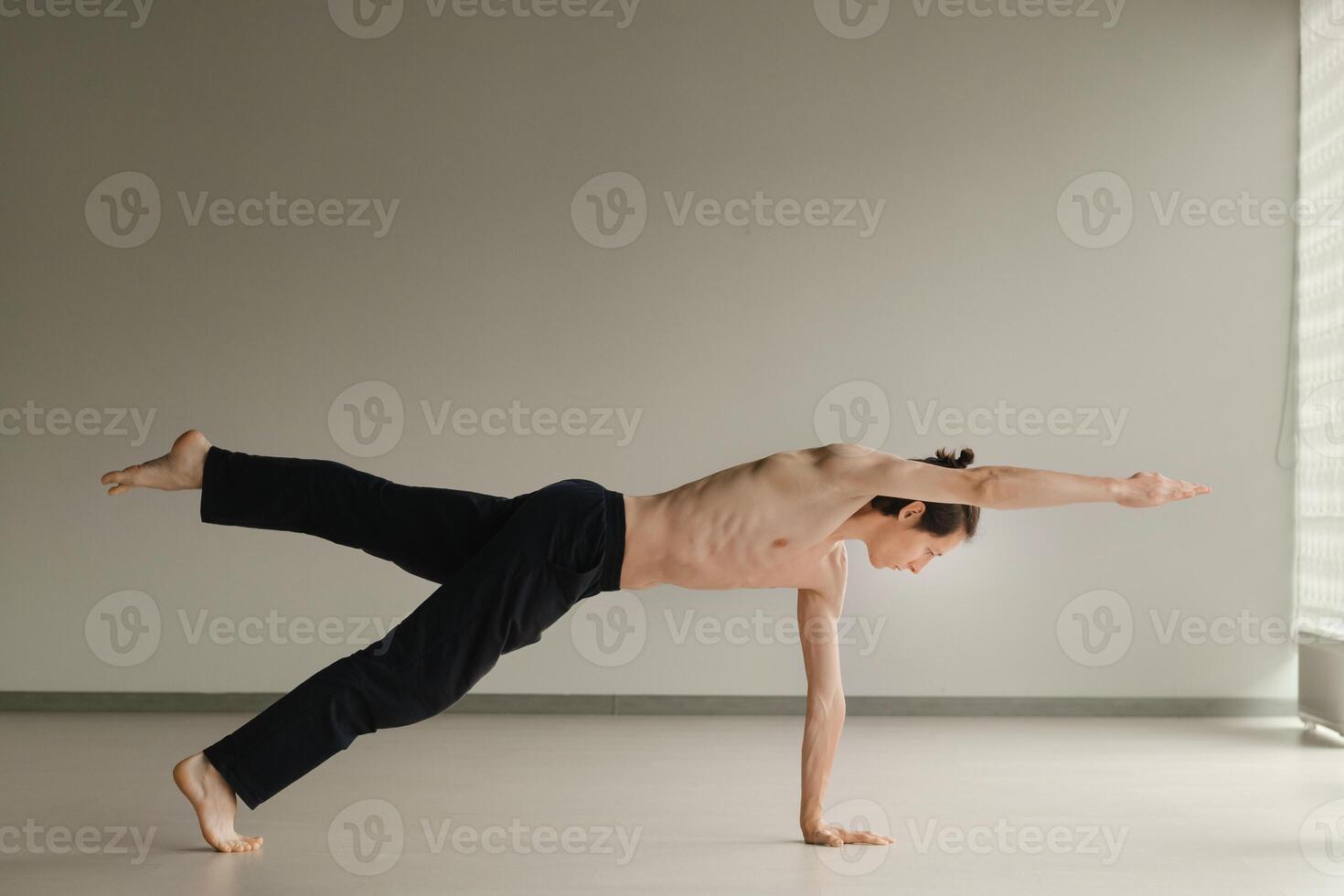a man with a naked torso does yoga in the gym. the concept of a healthy lifestyle photo