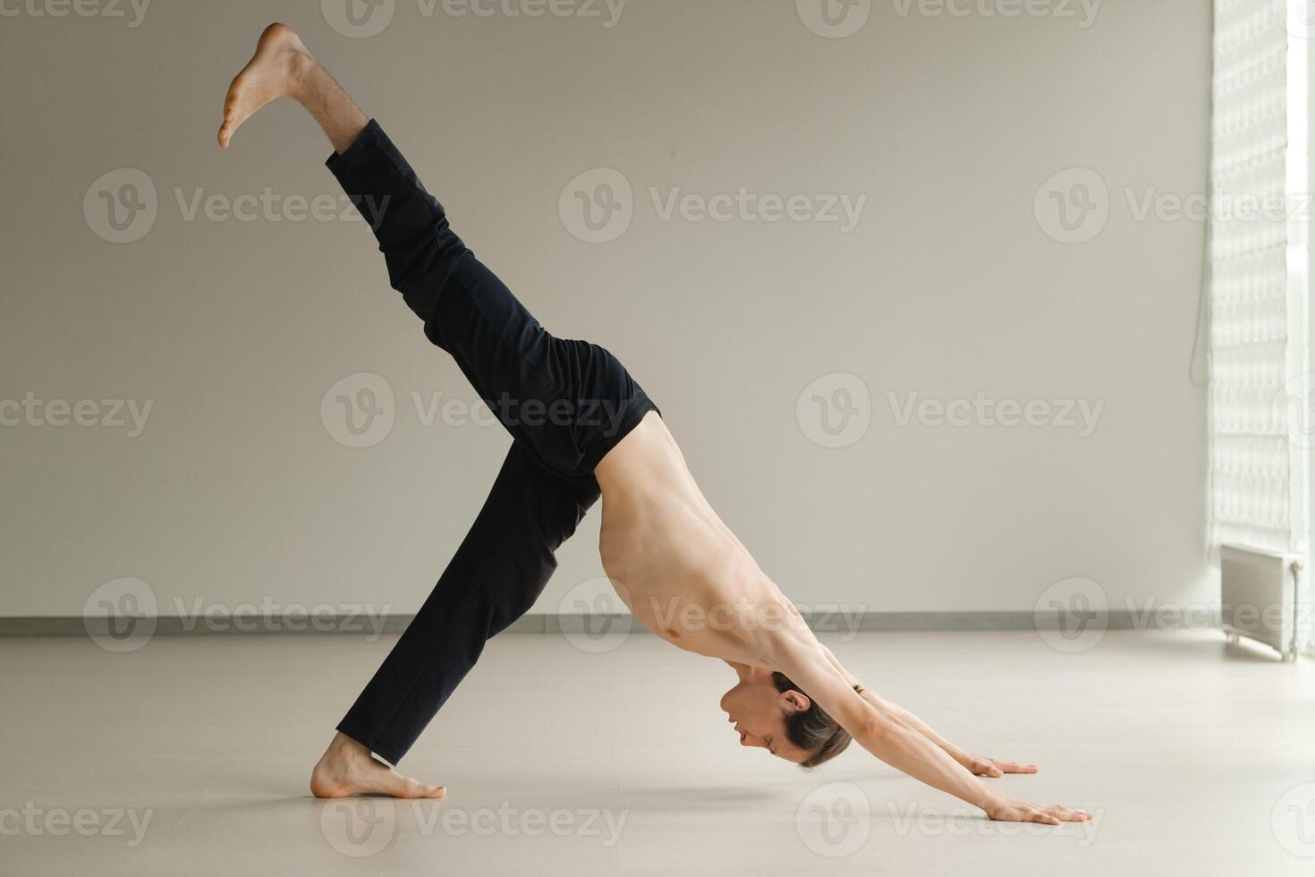 a man with a naked torso does yoga in the gym. the concept of a healthy lifestyle photo