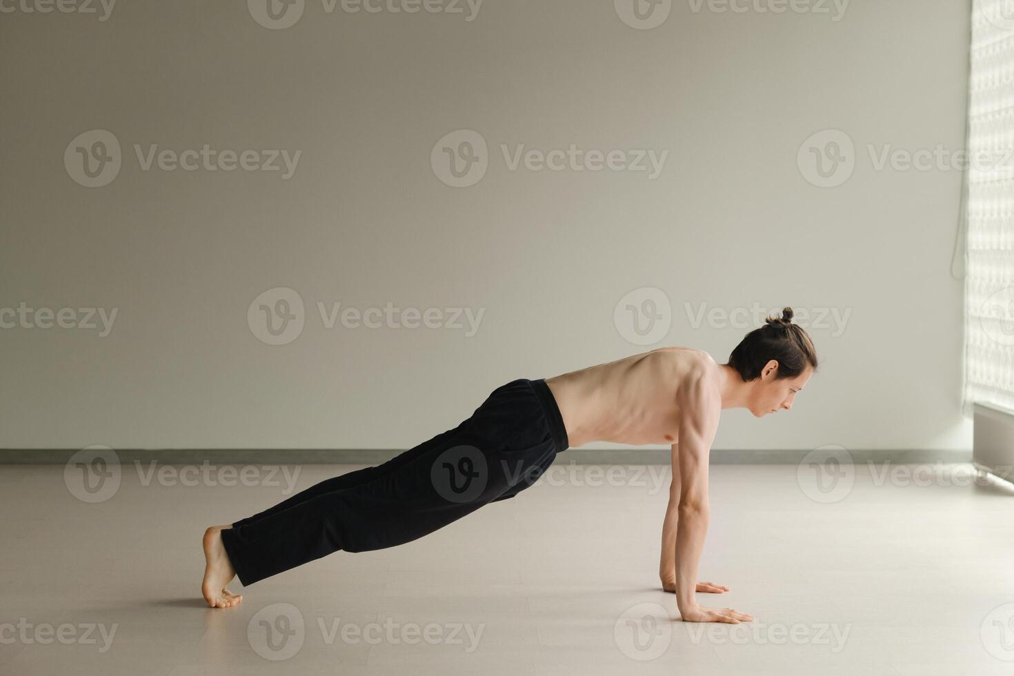 a man with a naked torso does yoga in the gym. the concept of a healthy lifestyle photo