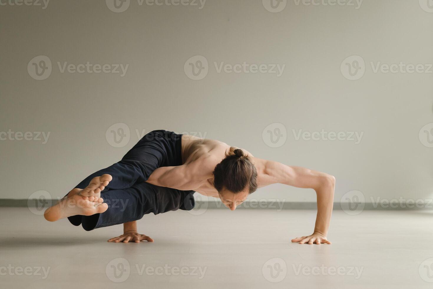 a man with a naked torso does yoga in the gym. the concept of a healthy lifestyle photo