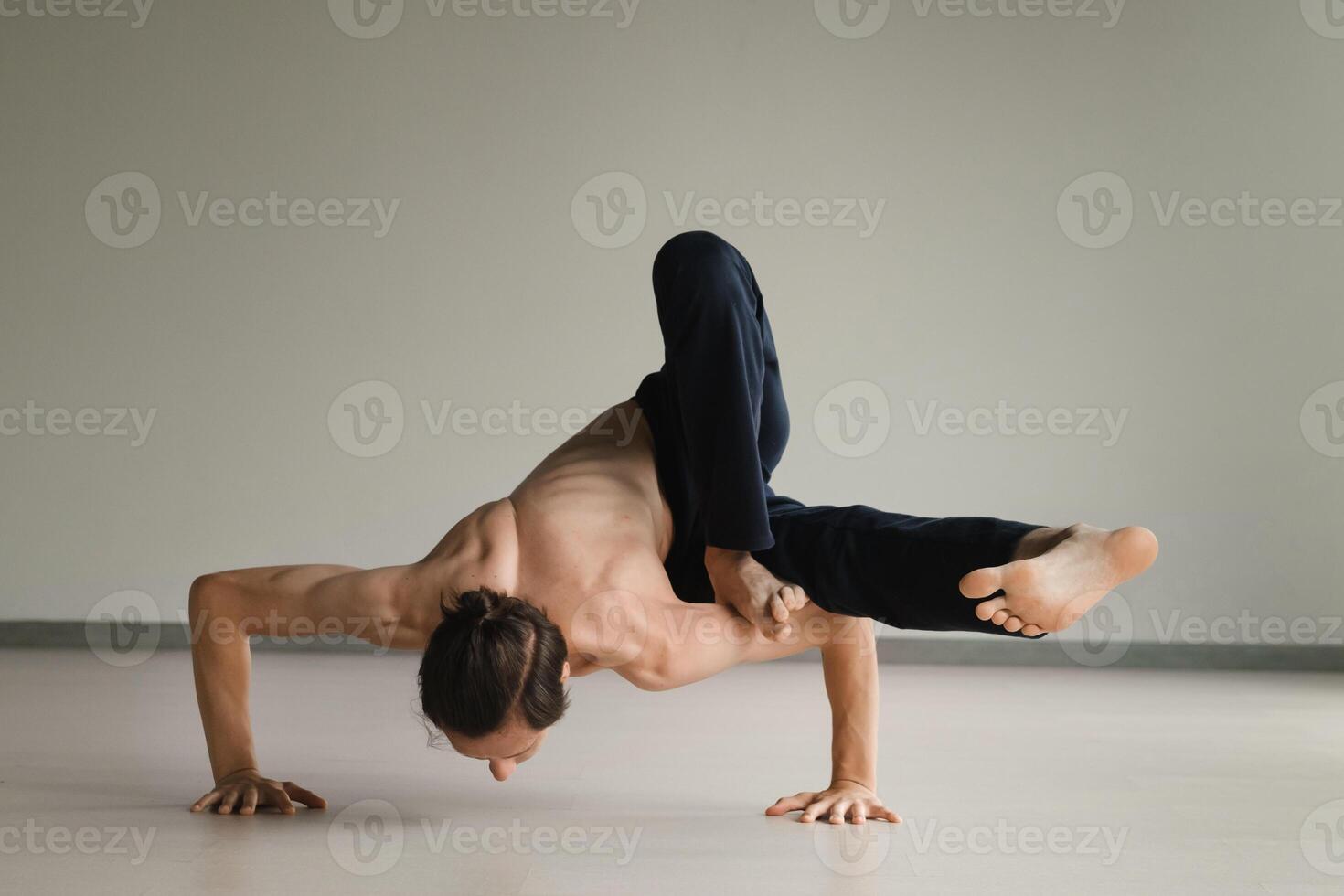 a man with a naked torso does yoga in the gym. the concept of a healthy lifestyle photo